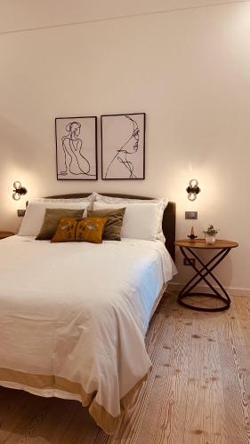 a bedroom with a large white bed and a table at Maison Opéra in Palermo