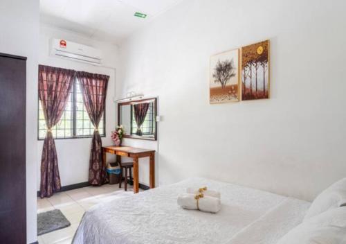 a bedroom with a bed and a desk in it at Shah Alam Golden Homestay 4 Rooms, 3 Bathrooms Seksyen 7 near uitm icity in Shah Alam