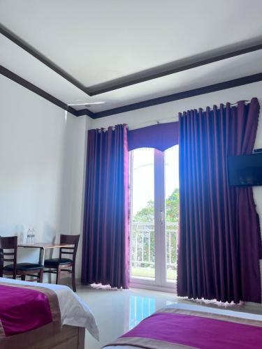 a bedroom with purple curtains and a window at Lak View hotel in Lien Son