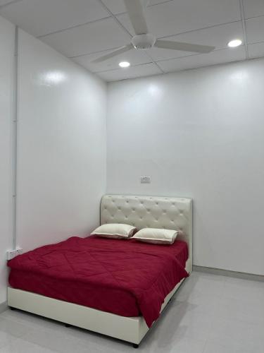 Homestay Wan : غرفة بيضاء مع سرير وبطانية حمراء