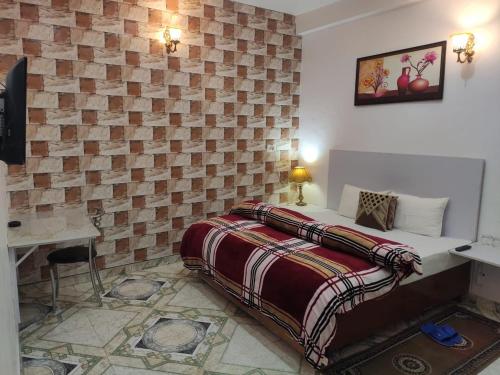 a bedroom with a bed and a brick wall at Solan Regency in Solan