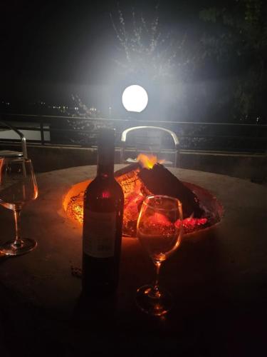 a bottle of wine and two glasses on a table at Le Bamboo Guest House And Boat Cruise in Hartbeespoort