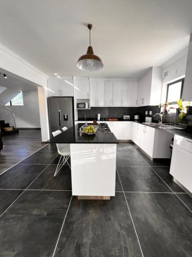 a kitchen with white cabinets and a black counter top at 2nd on Strand in Cape Town