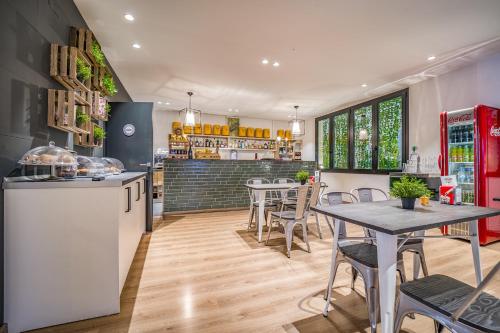 una cucina e una sala da pranzo con tavoli e sedie di Glaner Hotel Cafe ad Andorra la Vella