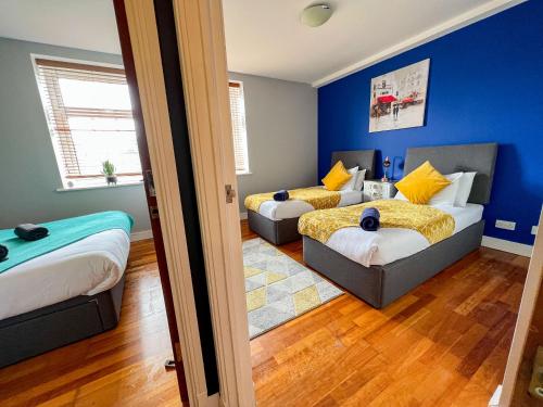 2 Betten in einem Zimmer mit blauen Wänden in der Unterkunft Modern Free Private Parking Central Reading 2 bedroom in Reading
