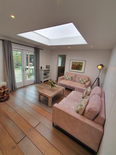 a living room with two couches and a skylight at Holiday home De Waterput in Bergen NH in Bergen