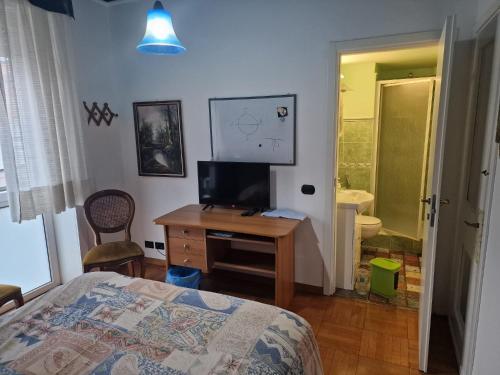 1 dormitorio con 1 cama y escritorio con TV en B&B Cavaliere, en Milán