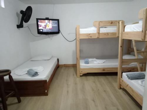um quarto com 2 beliches e uma televisão em Estadio APARTE HOTEL 203 em Medellín