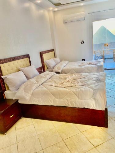 two beds sitting next to each other in a room at Enjoy Giza Pyramids View in Cairo