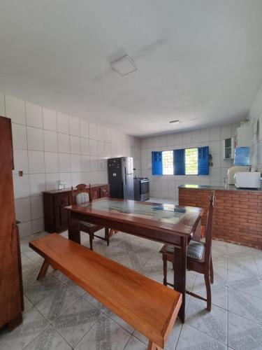 une cuisine avec une table en bois et deux bancs dans l'établissement Casa de Praia - Francês/Marechal Deodoro, à Marechal Deodoro