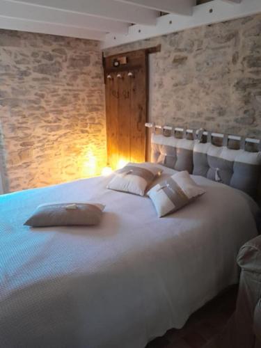 une chambre avec un grand lit blanc avec des oreillers dans l'établissement Plage et commerces à pieds ! Gîte Eugène, à Saint-Hilaire-de-Riez