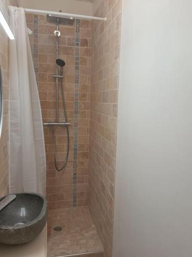 La salle de bains est pourvue d'une douche et d'un lavabo noir. dans l'établissement Plage et commerces à pieds ! Gîte Eugène, à Saint-Hilaire-de-Riez