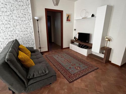 een woonkamer met een bank en een tv bij Appartamento in centro a Spoleto in Spoleto