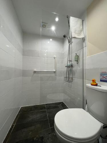 a white bathroom with a toilet and a shower at Old Manor House in Axbridge