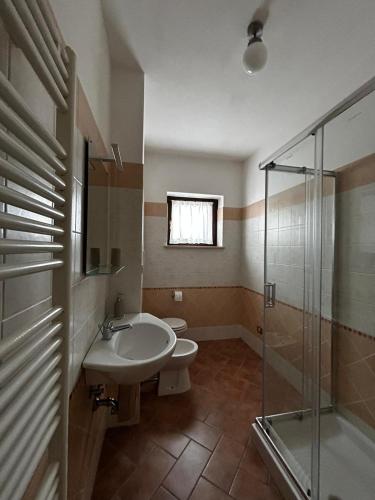 a bathroom with a sink and a glass shower at Appartamento in centro a Spoleto in Spoleto