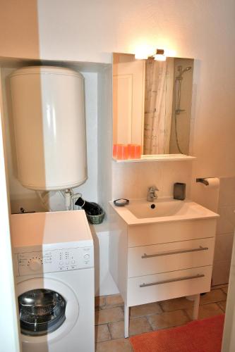 une petite salle de bains avec un lave-linge et un lavabo dans l'établissement At'Home, au centre du vieux Montelimar, cosy, wifi, à Montélimar