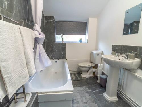 a bathroom with a sink and a tub and a toilet at Pass the Keys Beautiful Home near City Centre in Nottingham