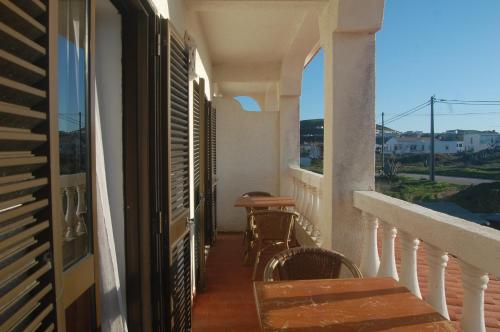a balcony of a house with a table and chairs at CASA DA HORTA in Aljezur