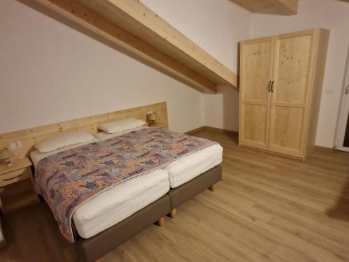ein Schlafzimmer mit einem Bett und einer Kommode darin in der Unterkunft Appartamento SOMEDA in Moena