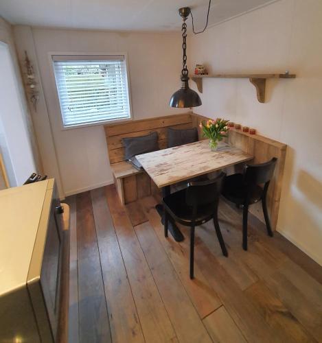 a dining room with a table and chairs and a window at Holiday home De Waterput in Bergen NH in Bergen