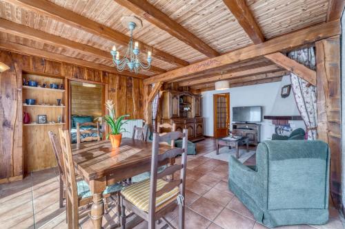 - une salle à manger et un salon avec un plafond en bois dans l'établissement AU PIED DES CIMES meuble de tourisme 3 etoiles classement 2023, à Marlens