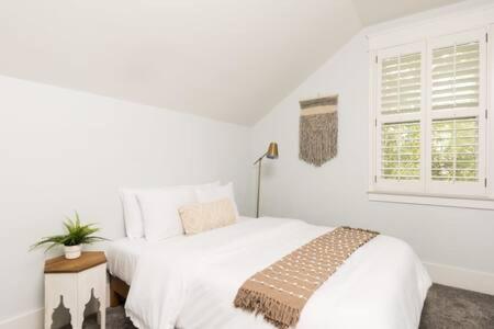 a white bedroom with a bed and a window at The Lillian House - Steps to Five Points in Nashville