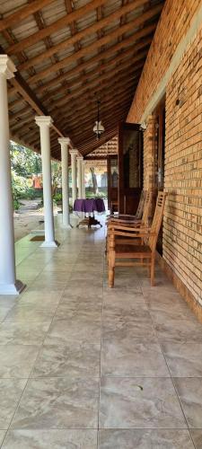 a patio with chairs and a table and a brick wall at Nature love Negombo in Kochchikade