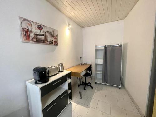 a small office with a desk and a refrigerator at Studio confortable dans le centre de Douai in Douai