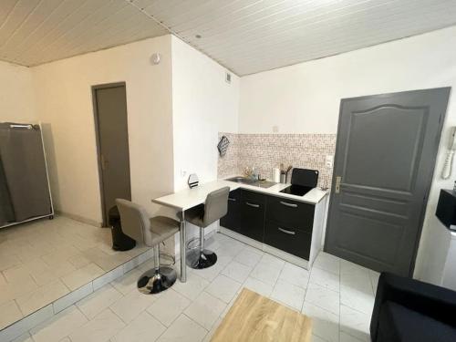 a kitchen with a counter and a table and chairs at Studio confortable dans le centre de Douai in Douai
