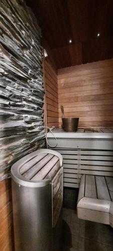 una sauna con aseo y pared de piedra en Oulujoen Onni, en Muhos