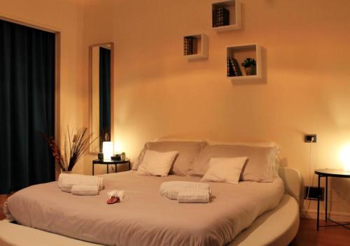 uma grande cama branca com duas toalhas em Bracco Rooms & Suites em Matera