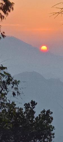 een zonsondergang boven een berg met de zon in de lucht bij Saveen View Ella in Ella