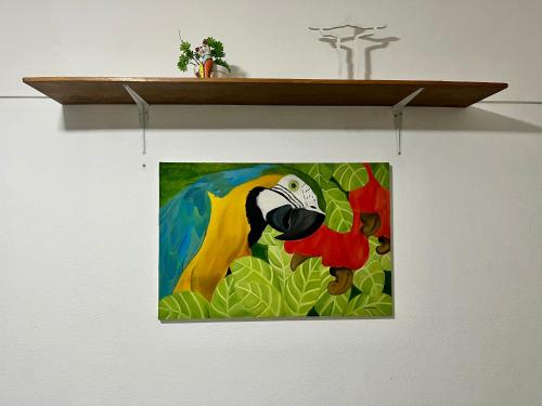 una pintura de un loro colgando en un estante en Studio no Largo da Carioca - Rio de Janeiro, en Río de Janeiro