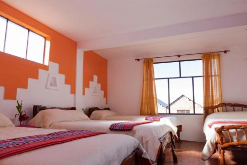 - un groupe de lits dans une chambre avec fenêtres dans l'établissement Hostal Margarita Isla del Sol Norte comunidad Challapampa, à Comunidad Challapampa