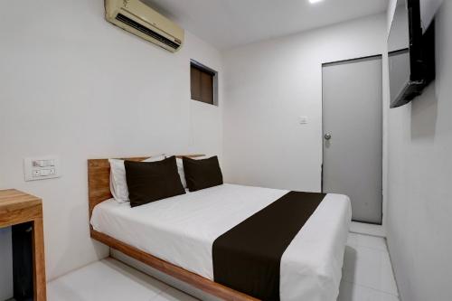 a bedroom with a bed in a white room at OYO Hotel Vrindavan Residency in Mumbai