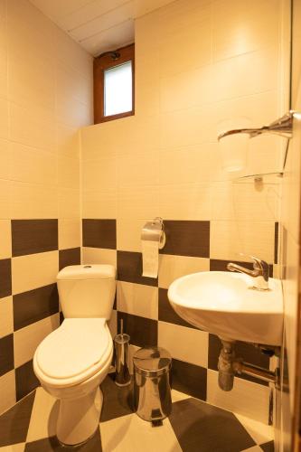 a bathroom with a toilet and a sink at Casa de Artes Guest House in Balchik