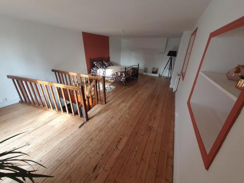 a living room with a bed and a wooden floor at Au pied de la forteresse in Chinon