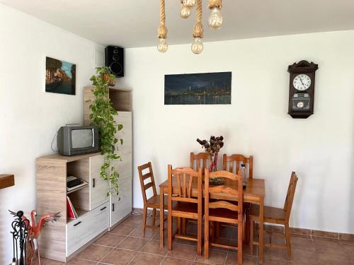 comedor con mesa y TV en Villa Rubio Vega, en Chiclana de la Frontera