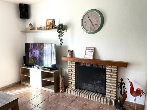 sala de estar con chimenea y reloj en la pared en Villa Rubio Vega, en Chiclana de la Frontera