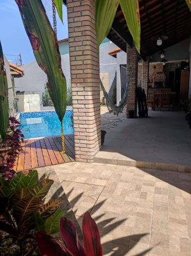 eine Terrasse mit einer Backsteinsäule und einem Pool in der Unterkunft Casa para Relaxar in Poá