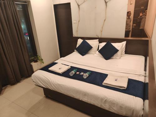 a bedroom with a bed with towels and drinks on it at Hotel Anand Palace in Shirdi