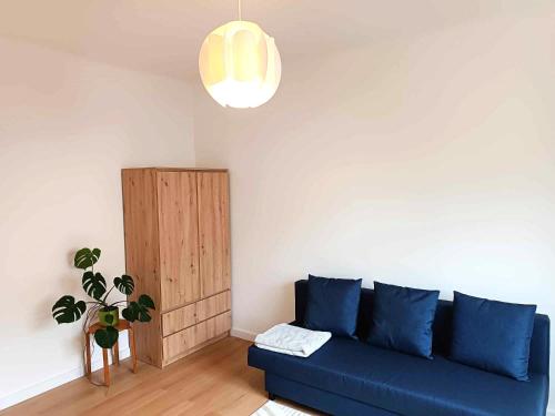 a blue couch in a living room with a potted plant at Comfort apartment in Warsaw