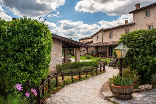ścieżka prowadząca do domu z płotem i kwiatami w obiekcie Agriturismo Casale nel Parco dei Monti Sibillini w mieście Nursja