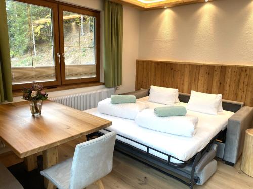two beds in a room with a table and a table and chairs at Reiteralm Sonnenblick in Schladming