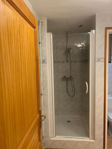 une douche avec une porte vitrée dans une salle de bain dans l'établissement La petite Ballière, à Champfleur