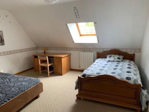 une chambre avec un lit, un bureau et une fenêtre dans l'établissement La petite Ballière, à Champfleur
