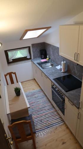 uma pequena cozinha com um lavatório e uma mesa em Ferienwohnung Zahnder em Ruhpolding