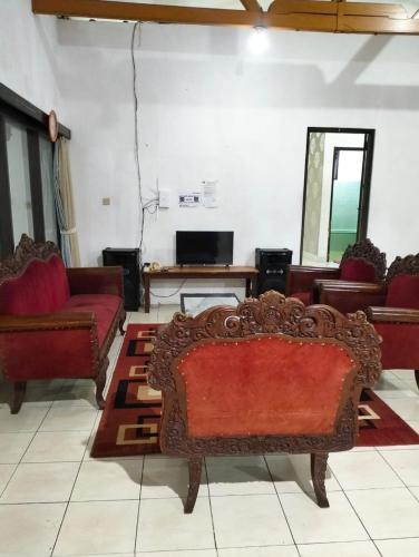 un soggiorno con divano rosso e tavolo di Villa sagitarius a Bogor
