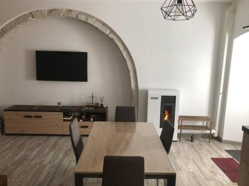 Una sala de estar con una mesa y una chimenea. en Il nido vicino Castel di Sangro ed Alfedena, en Montenero Val Cocchiara