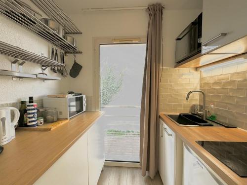d'une cuisine avec un comptoir, un évier et une fenêtre. dans l'établissement L'Epi - Balcon - 2 vélos -Proche parking gratuit, à Avignon